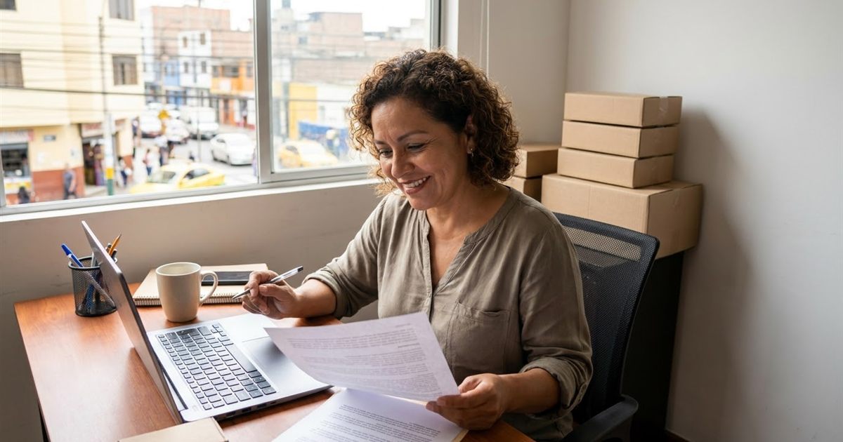 Dueña de un courier leyendo la política de reembolso de un software de paquetería antes de pagar su primera suscripción